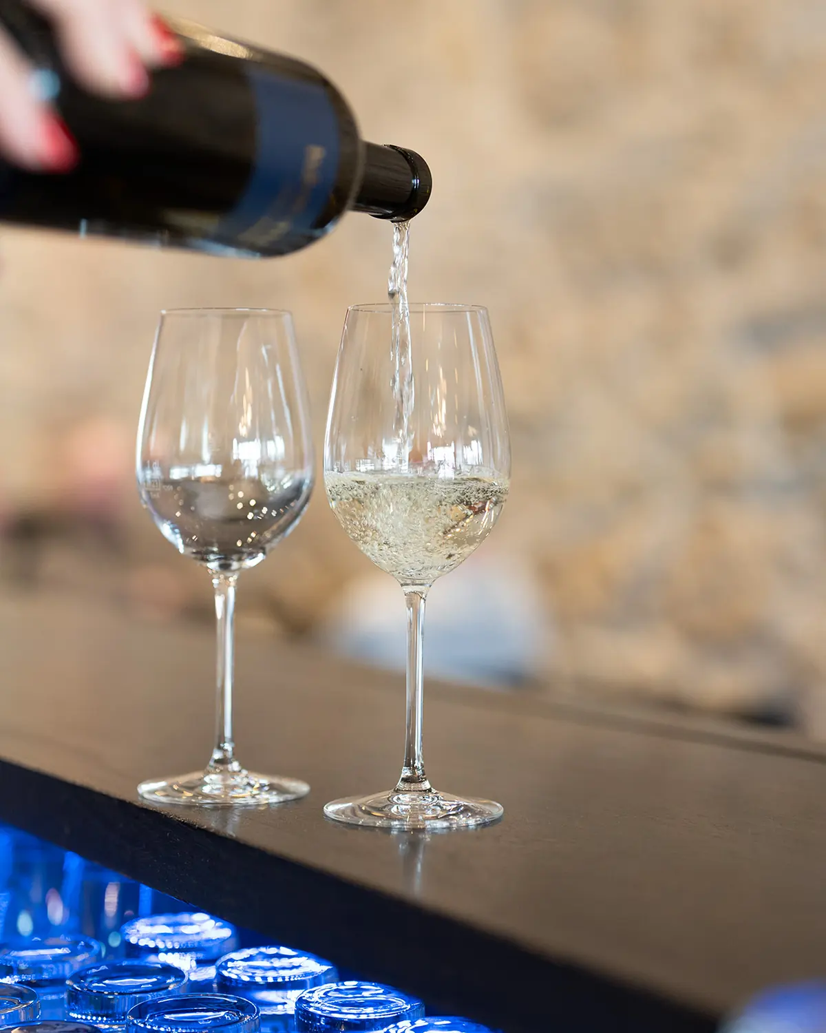 Weisswein wird an der Bar in Gläser eingeschenkt