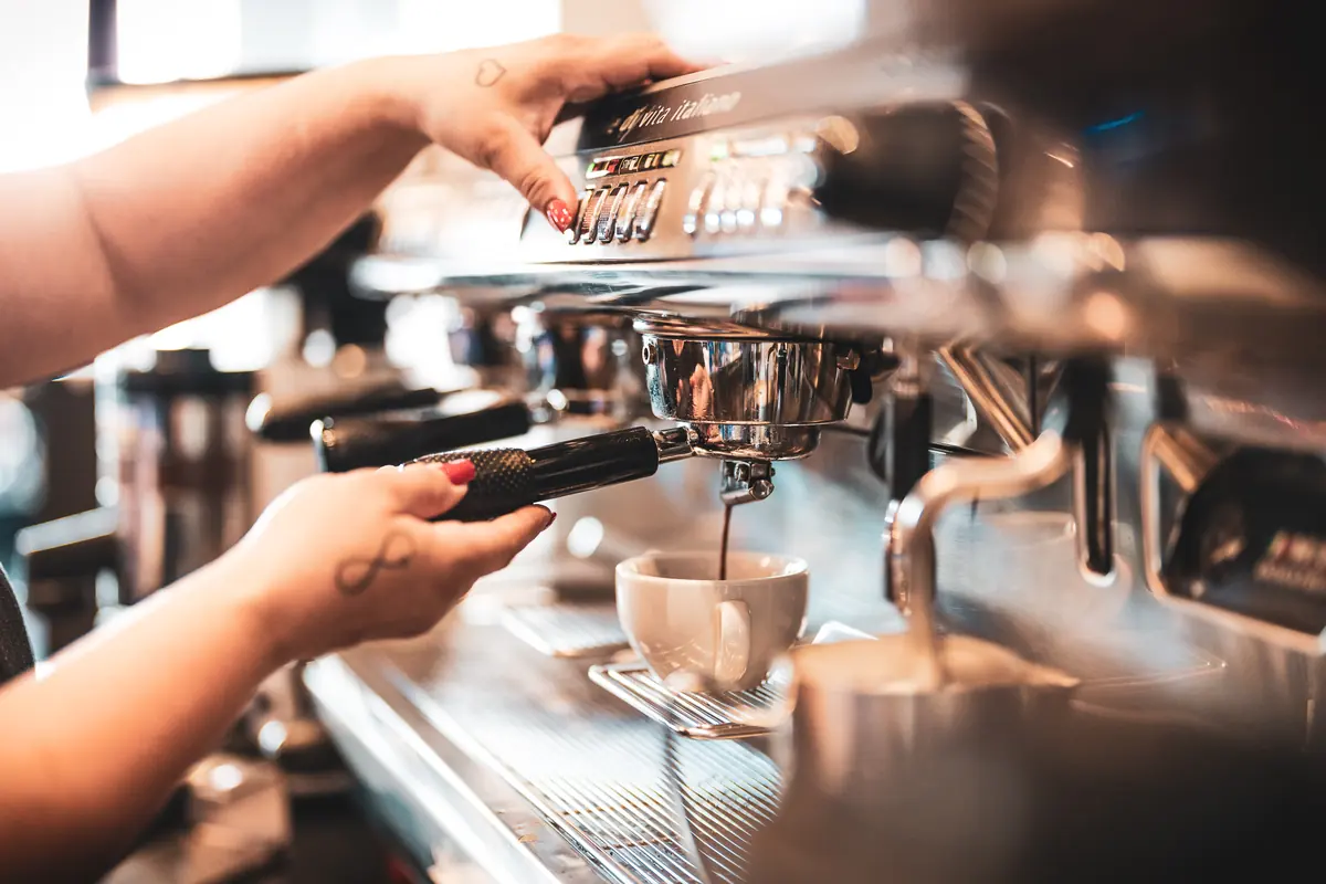 Hände an der Espressomaschine