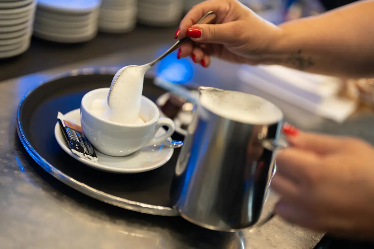 Ein Cappuccino wird mit Milchschaum vollendet