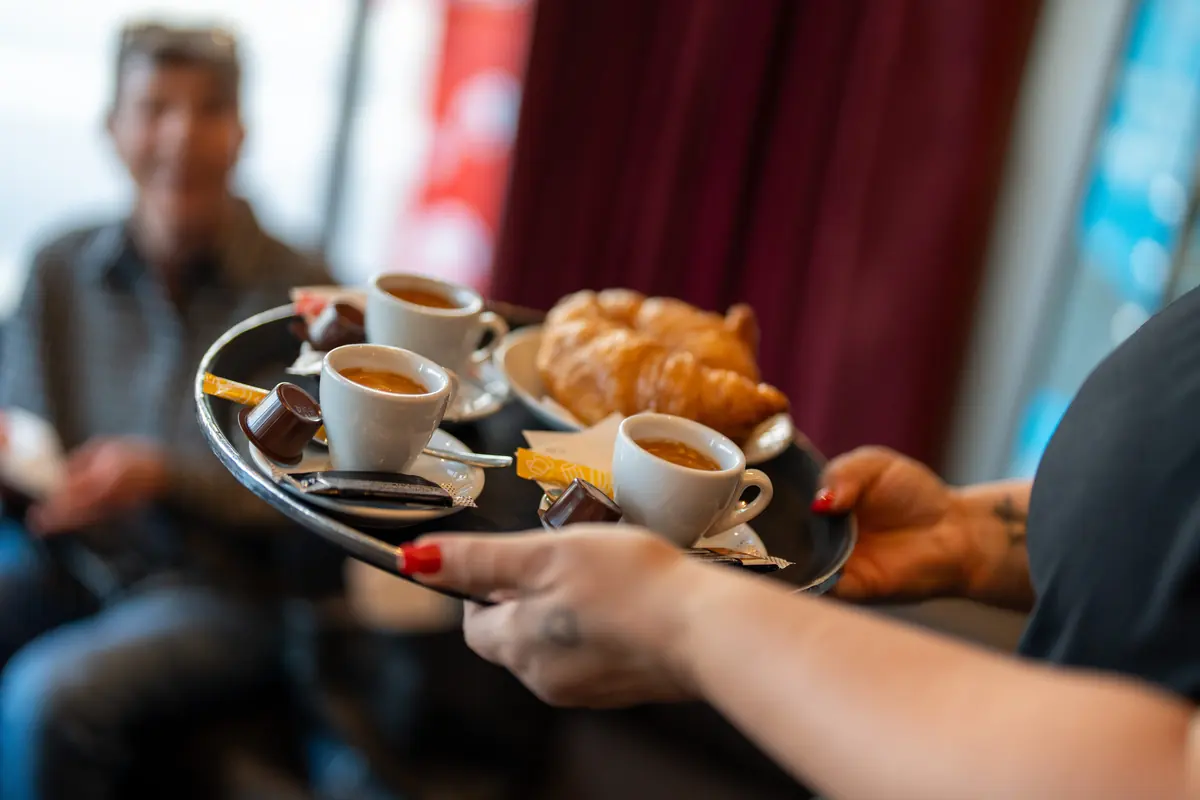 Service mit Tablett, Kaffee und Croissants